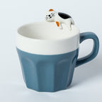 A cup full of warmth — and a cat on top!