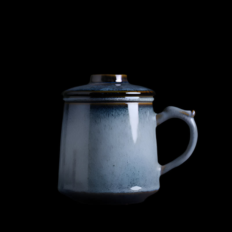 Blue ceramic mug with a lid on a dark background

