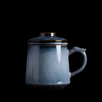 Blue ceramic mug with a lid on a dark background

